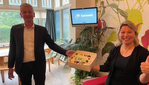 Zweder Bergman (VZVZ) feliciteert Metha Bregman (Careweb) met taart