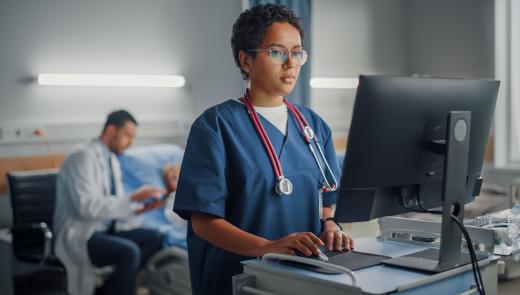 Verpleegster checkt gegevens patiënt op computer